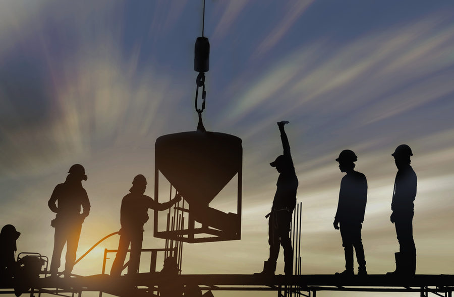 A construction crew silhouetted at sunset