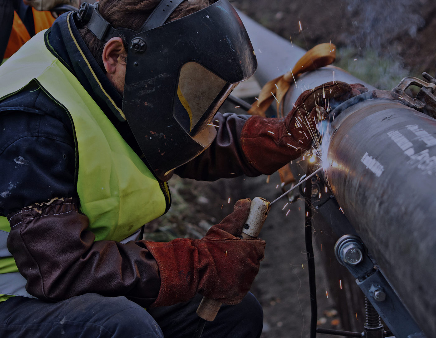 A pipefitter welding a section of steel pipe